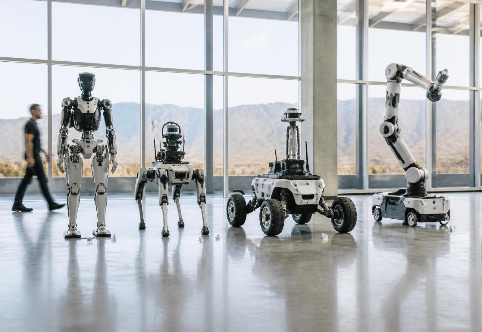 Engineers inspecting a tracked competition robot in a technical pit area
